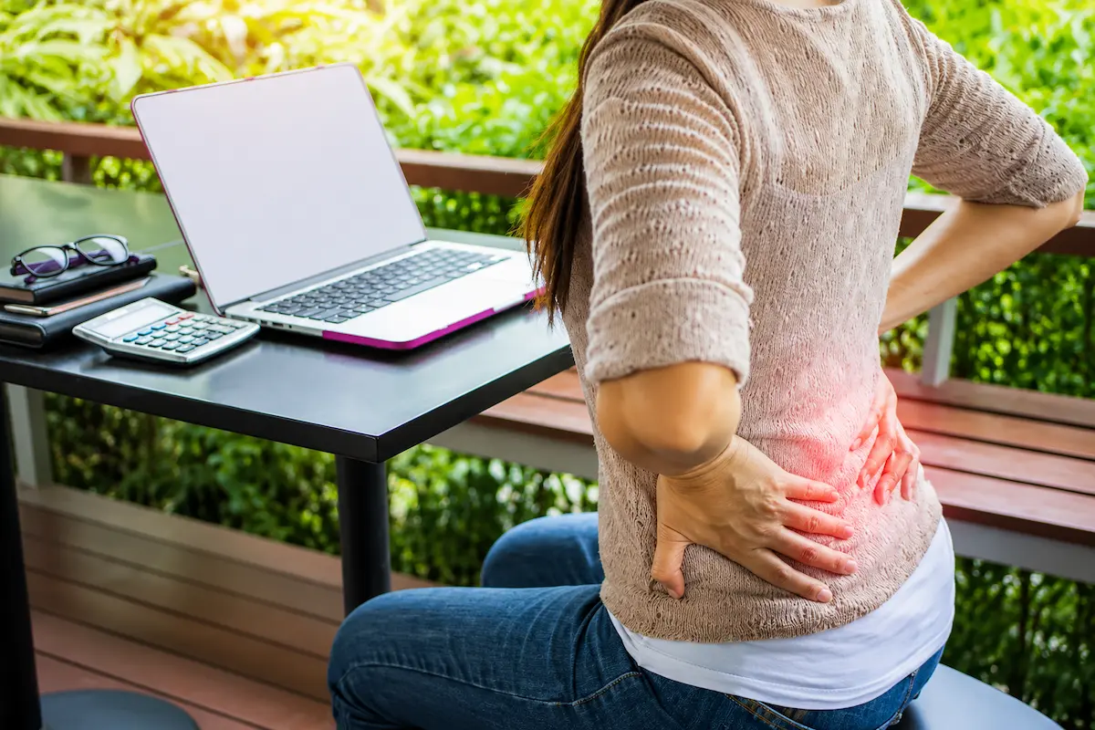 Woman experiencing back pain while preparing for an acupuncture appointment