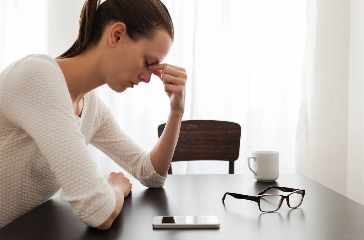 Adult with tension headache symptoms at a desk