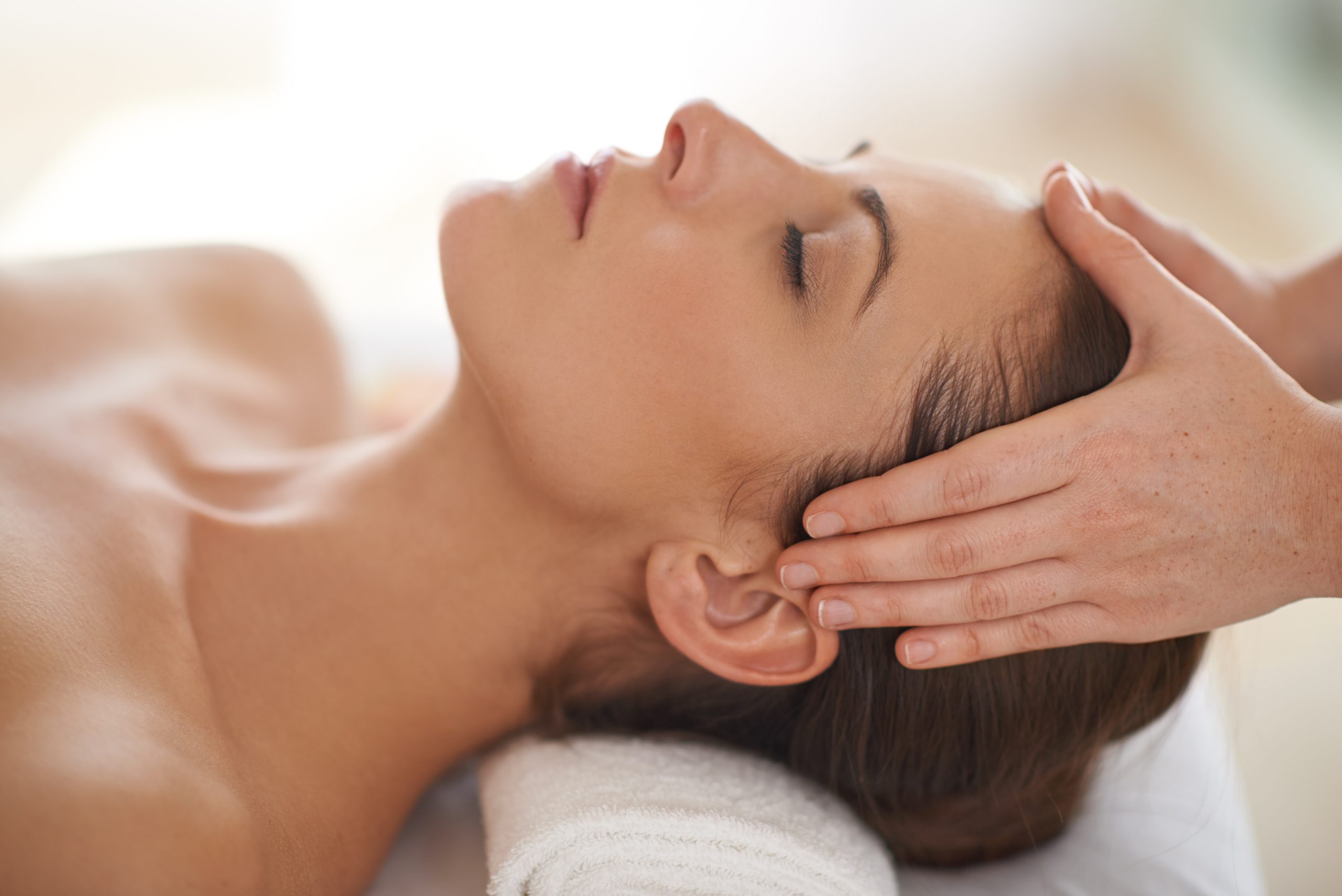 Pure relaxation. Close up shot of a young woman receiving a head massage at a spa.