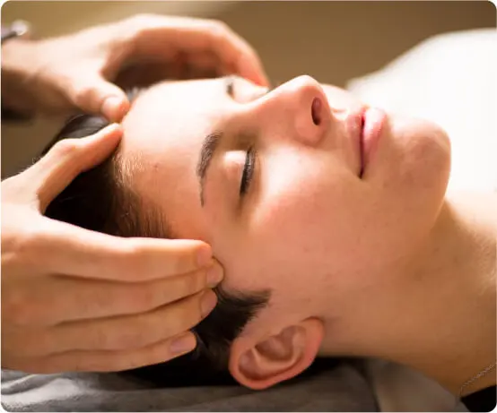 Therapist performing temple massage for headache and migraine relief in East Setauket NY