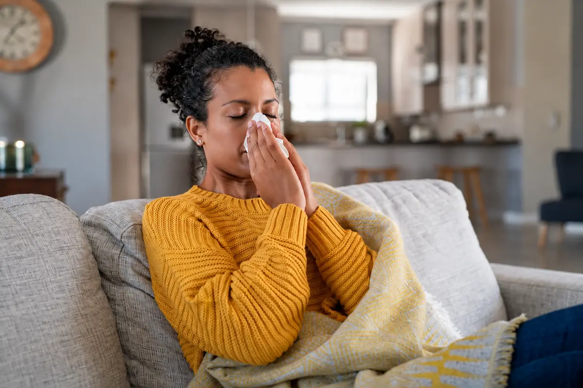 Adult experiencing sinus pressure and seasonal allergy symptoms during late summer
